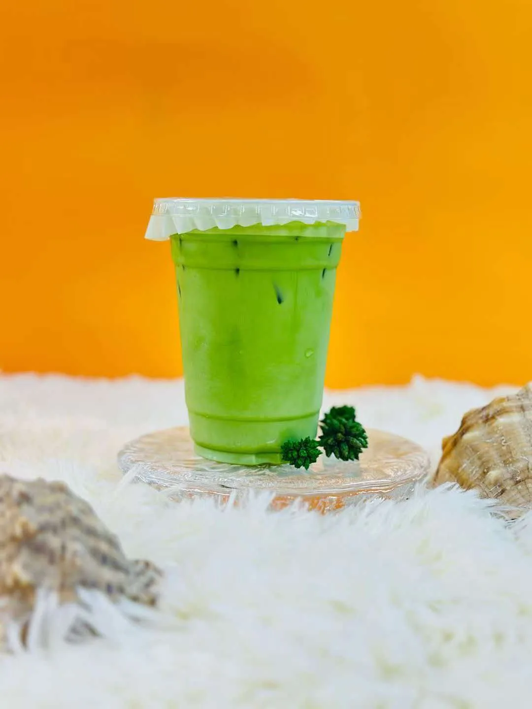 Iced matcha against an orange backdrop