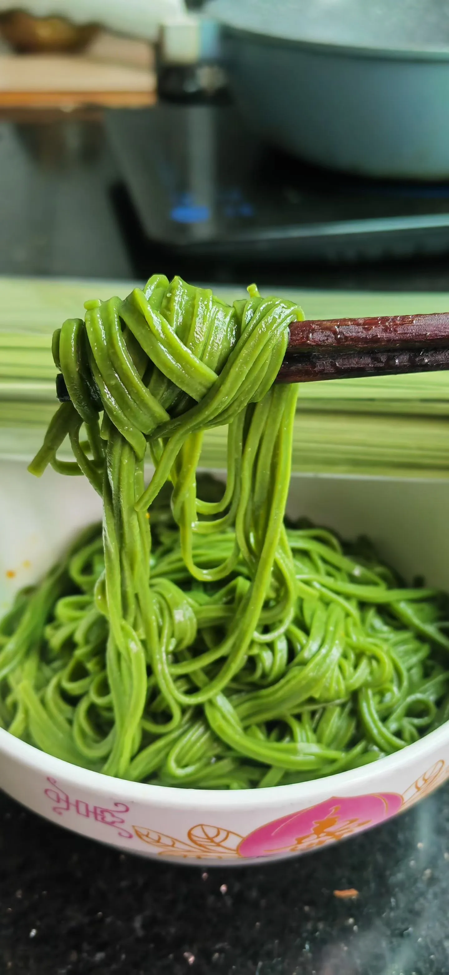 Matcha noodles lifted by chopsticks